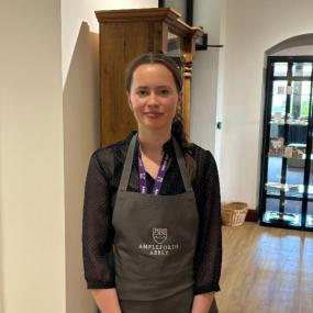 Woman with brown tied back hair wearing Ampleforth Abbey branded apron and uniform