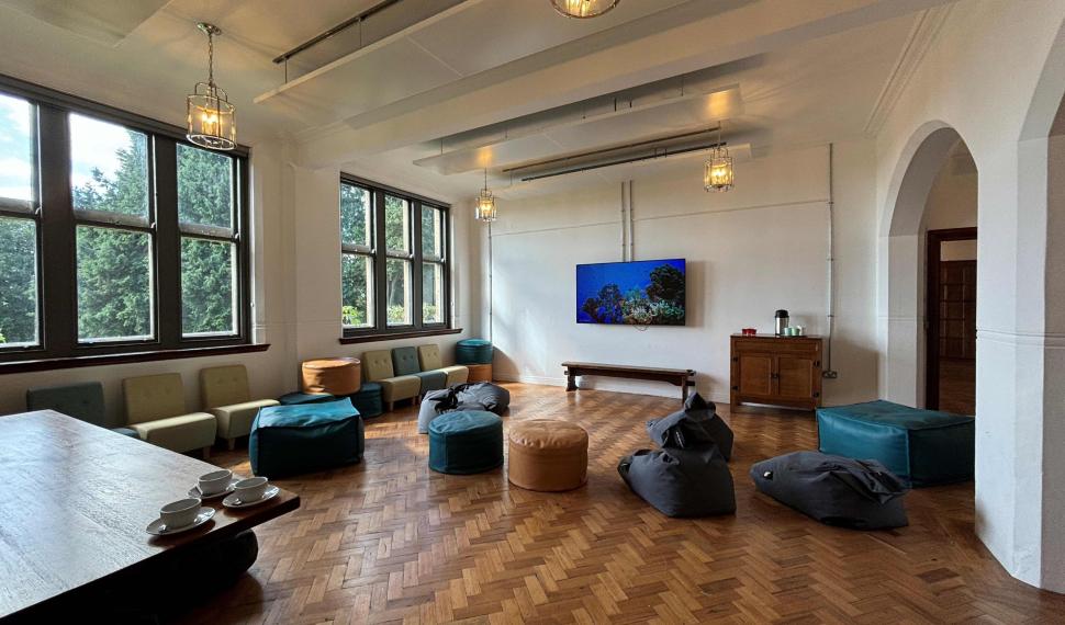 activity room with wooden floors, a large TV and bean bags