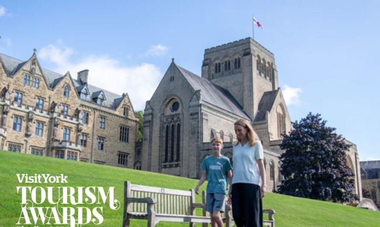 Mother and son walking in front of Ampleforth Abbey in sunshine