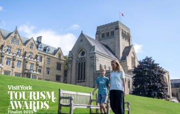 Mother and son walking in front of Ampleforth Abbey in sunshine